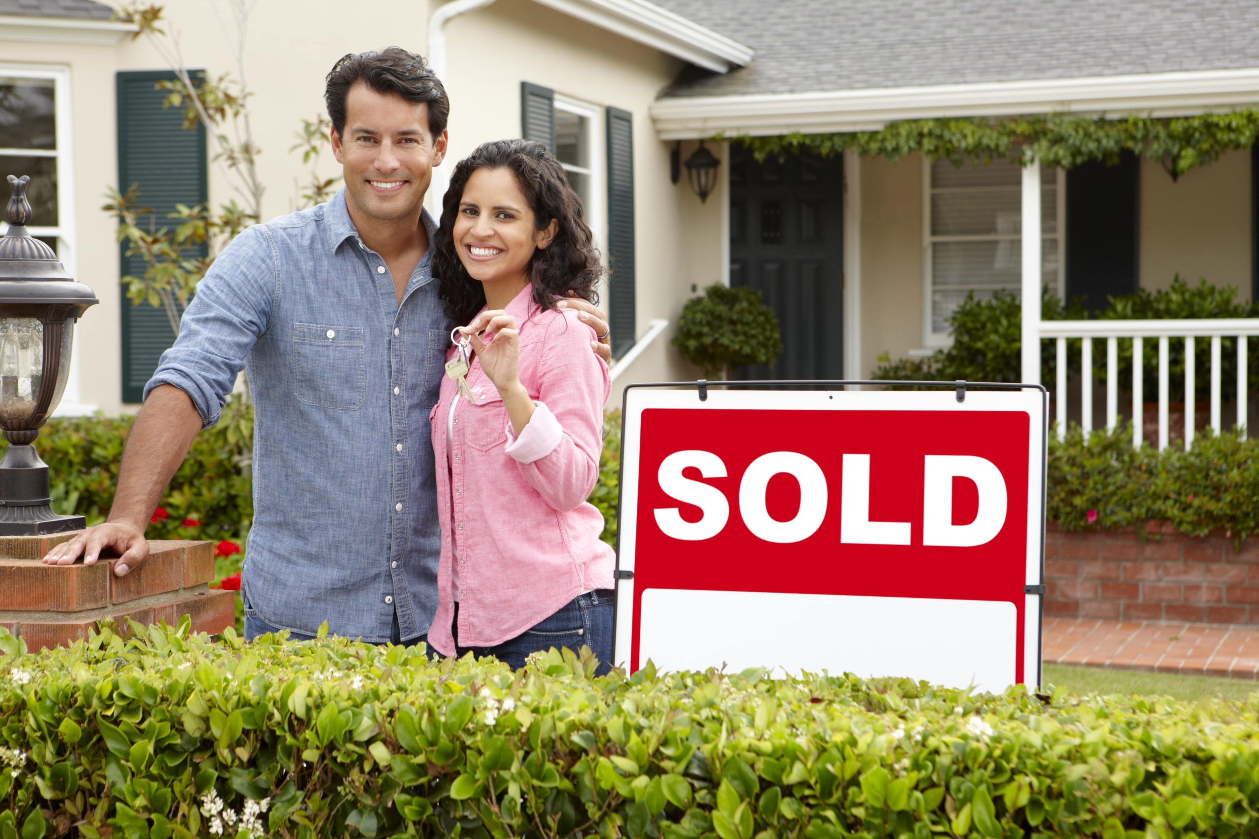 Smiling Couple In Front of Their New Home